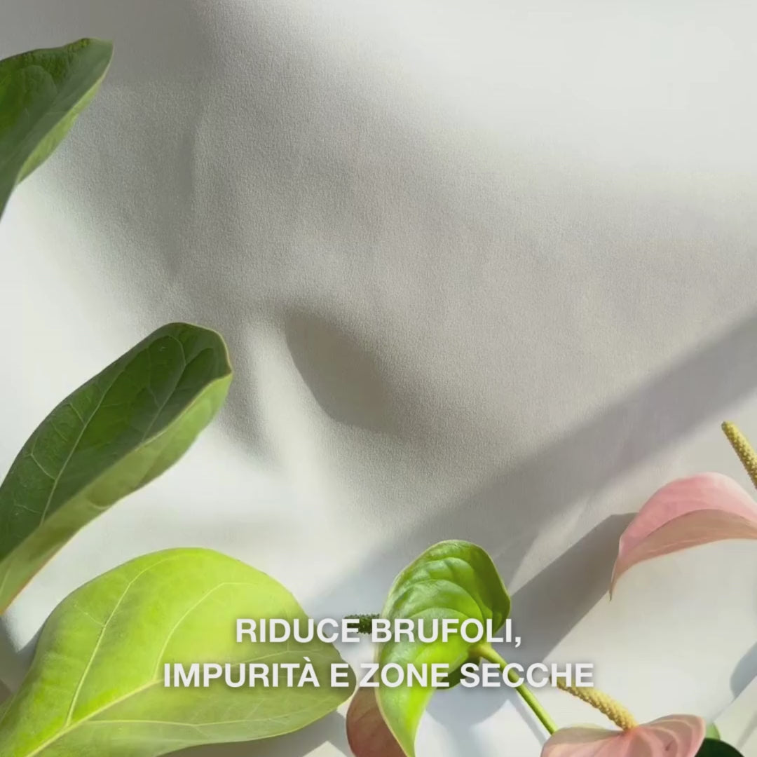 Primo piano di una mano che dosa una piccola quantità di Body Lotion leggera e cremosa con acido salicilico nel palmo e la massaggia su pelle ruvida incline alle imperfezioni: la sua texture setosa e a rapido assorbimento esfolia delicatamente le cellule morte, idrata con acido ialuronico e lattico e migliora la texture con acido salicilico e niacinamide.