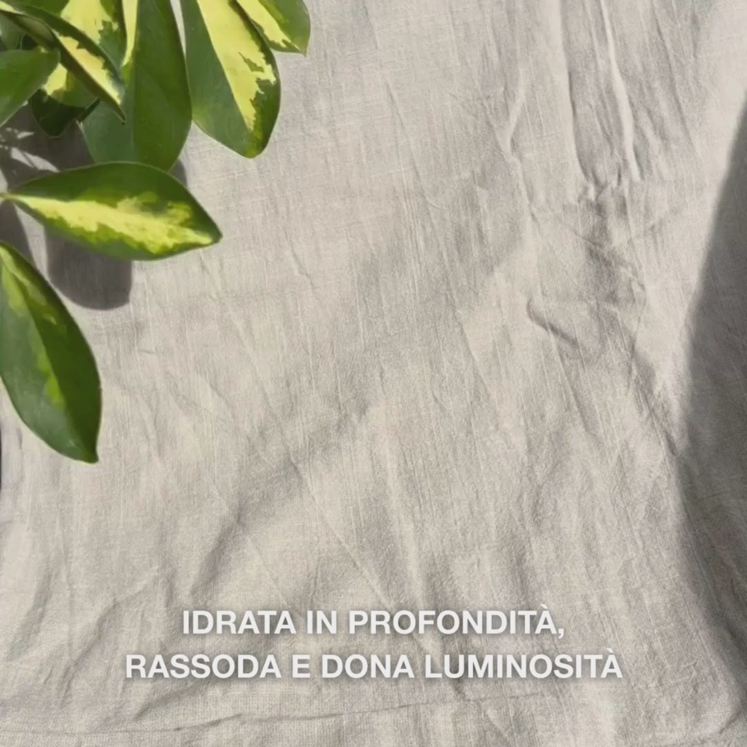 Primo piano di una donna che applica una maschera viso rosa intenso a base di vitamina B12 e collagene su pelle pulita: la stende su guance, fronte e mento, lasciando che la formula idratante al collagene e B12 doni una pelle calma, soda e luminosa.