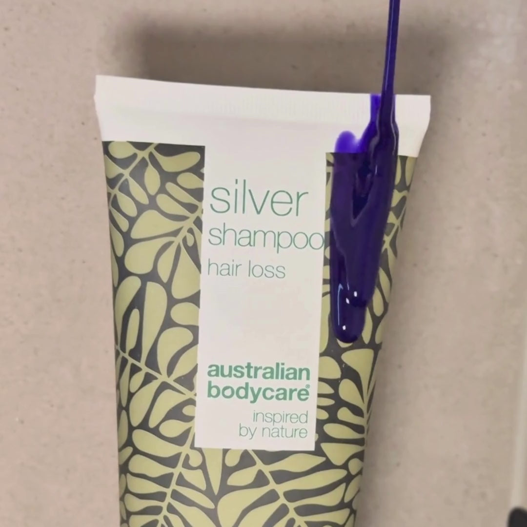 Video che mostra il nostro shampoo Hair Loss Silver con tonalità argento-viola applicato sui capelli bagnati sotto la doccia.