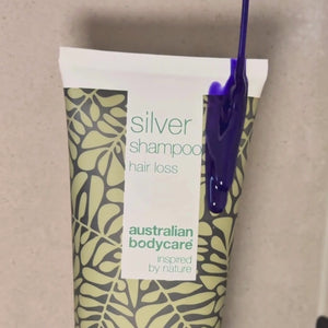 Video che mostra il nostro shampoo Hair Loss Silver con tonalità argento-viola applicato sui capelli bagnati sotto la doccia.